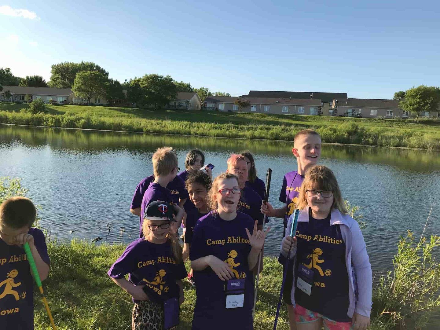 Group of student campers standing next to a pond